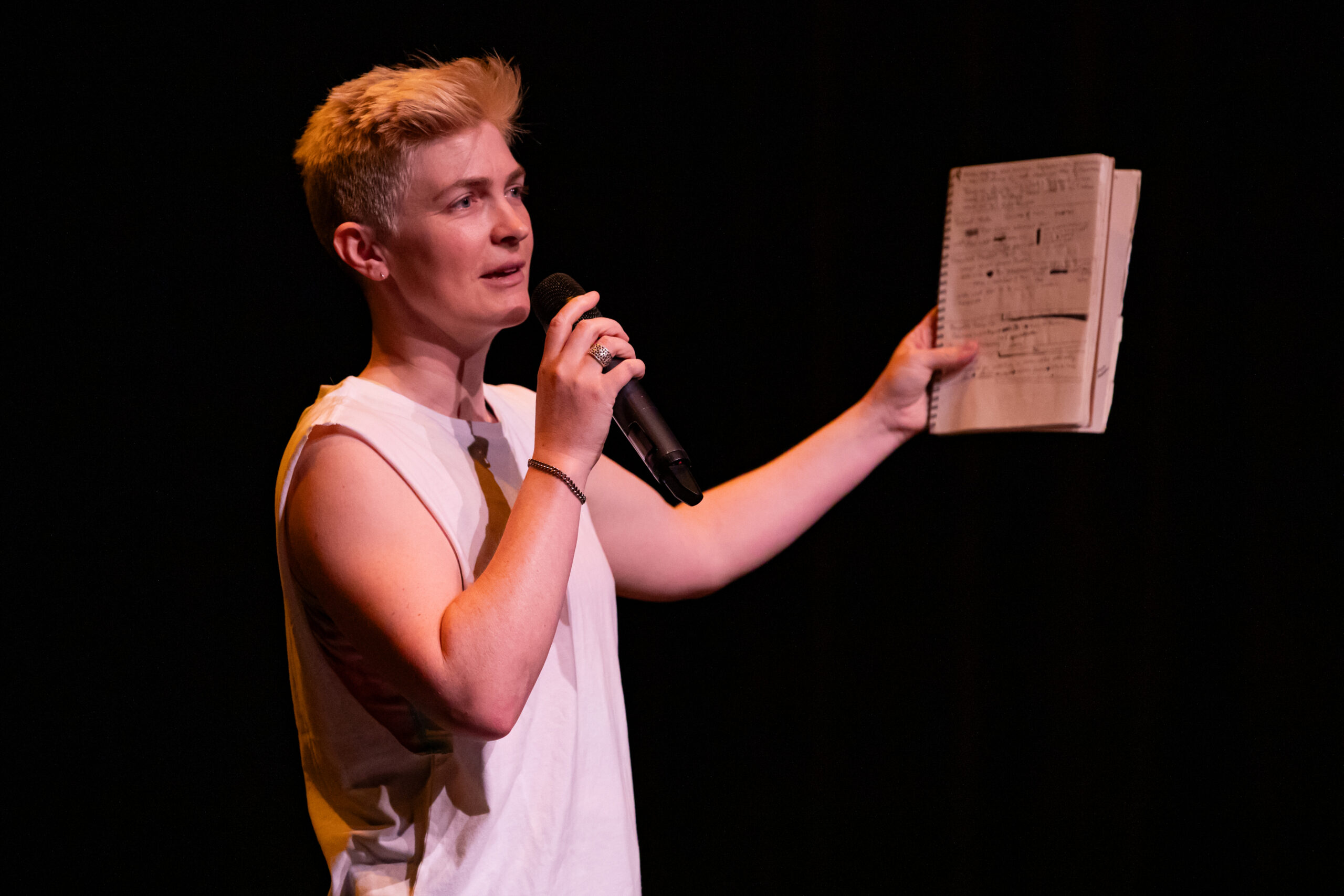 Nora Sharp holds a notebook and microphone.